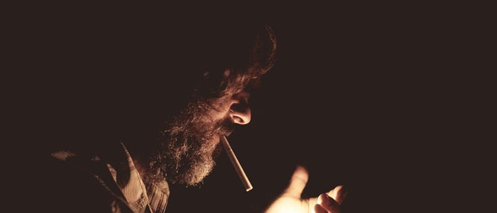 煙草を吸うひげの男性